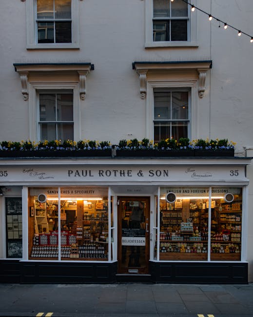 Image of Paul Rothe & Son, a traditional shop on Marylebone High Street, featuring a light-colored facade with decorative window frames and a flower box filled with yellow and purple flowers above the