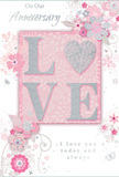 This anniversary card is shown as a delicate celebration of long-lasting love, with a style that would feel at home in a refined Marylebone living room. The central focus is the word LOVE, presented in raised, softly shimmering letters that blend blush pink, pearlescent white, and fine silver glitter. The texture is clearly embossed, giving the impression of something you could feel under your fingertips, much like running your hand over the layered petals of a fresh bouquet. The letters rest on a gentle, powder-pink background that glows quietly, offering a warm contrast without harsh edges. Around this focal point, a halo of stylized flowers and curling foliage sweeps outward in graceful arcs. The blooms are not highly realistic but instead suggested through slender lines and subtle shading in pale pinks, soft greys, and creamy whites, evoking roses and delicate spring blossoms you might see in the window of a local Marylebone florist. These floral motifs twist and intertwine like the stems in a hand-tied arrangement, their movement light and flowing rather than rigid or formal. Fine details-tiny petals, leaf tips, and delicate swirls-add a sense of motion, as if caught in a gentle indoor breeze. Threaded between and around the flowers, flowing script text carries sincere anniversary messages, written in an elegant, understated style that complements the visual softness of the card. The overall mood is calm, intimate, and quietly celebratory, suited to marking an anniversary in a cosy Marylebone flat after a stroll through nearby Paddington Street Gardens, honouring a relationship that feels both cherished and beautifully enduring.